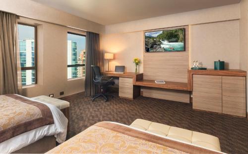 a hotel room with a desk and a bed at Hotel Regal Pacific Santiago in Santiago