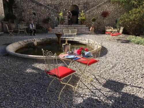 a table and chairs sitting in front of a fountain at Demeure des Vieux Bains in Provins