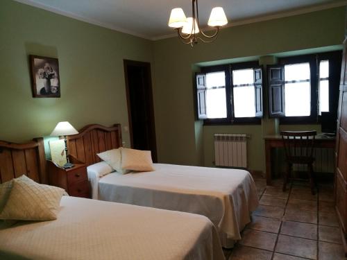 a bedroom with two beds and a table and a chair at Mesa del Conde in San Felices de los Gallegos