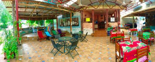 a room with tables and chairs in a building with presents at Yaxche Centro Hostal y Camping in Bacalar