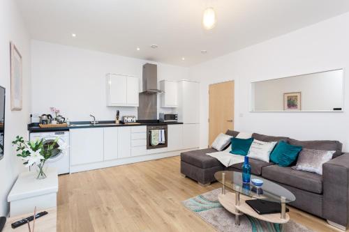 a living room with a couch and a table at Self-contained town centre one bedroom apartments by Helmswood Serviced Apartments in Redhill