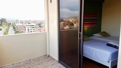 Habitación con vistas a una cama y una ventana en C&R apartments, en Cochabamba