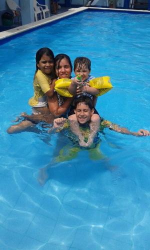 a group of people in a swimming pool at Hostal Aruba in Atacames