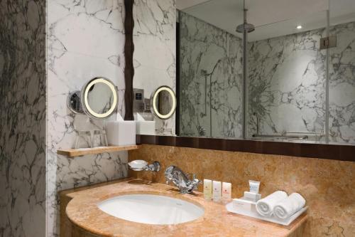 a bathroom with a sink and two mirrors at Crowne Plaza - Dubai Jumeirah by IHG in Dubai