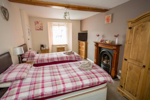 a bedroom with a red and white bed and a fireplace at The White Swan Inn in Lowick