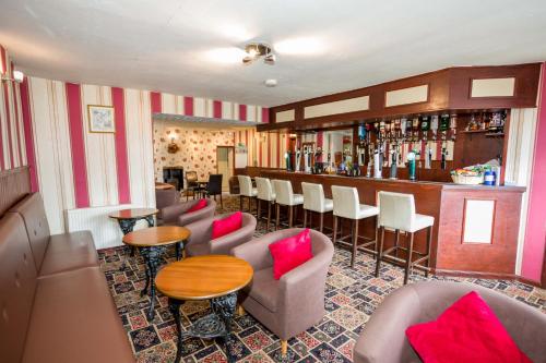a bar with a bunch of chairs and a table at The White Swan Inn in Lowick