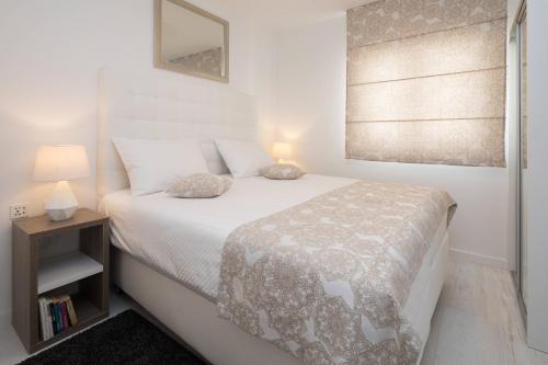 a bedroom with a white bed and a window at S Luxury Apartments in Split