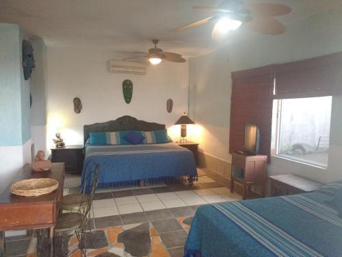 a bedroom with a bed and a table and a window at Casa Artista in Manzanillo