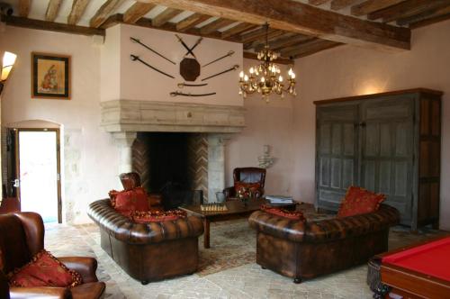 a living room with leather furniture and a fireplace at Demeure des Vieux Bains in Provins