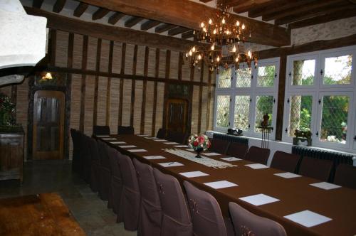 a long table and chairs in a room with windows at Demeure des Vieux Bains in Provins