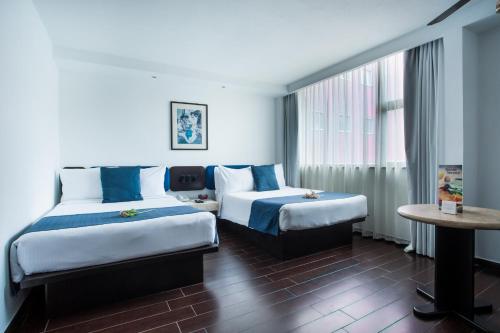 A bed or beds in a room at Hotel Real de Puebla