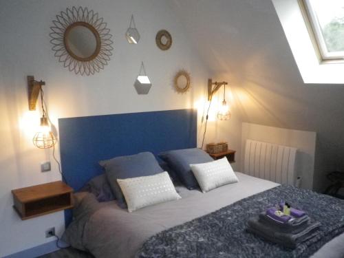 a bedroom with a large bed with a blue headboard at Le Brame - Chambres d'Hôtes in Avilly-Saint-Léonard