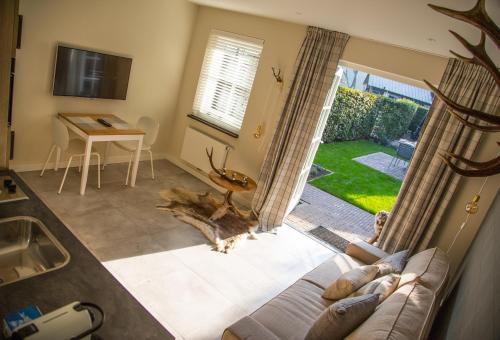 ein Wohnzimmer mit einer Couch und einem Tisch und einem Fenster in der Unterkunft De Verloren Sinjoor in Bladel