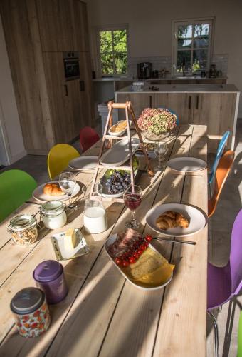 einen langen Holztisch mit Teller Essen drauf in der Unterkunft De Verloren Sinjoor in Bladel