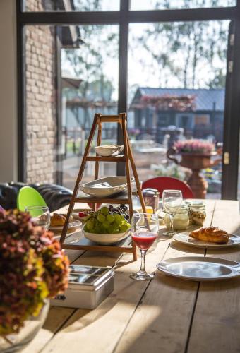 einen Holztisch mit Essen und Weingläsern darauf in der Unterkunft De Verloren Sinjoor in Bladel