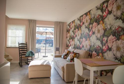 ein Wohnzimmer mit einem Sofa und einer Blumenwand in der Unterkunft De Verloren Sinjoor in Bladel