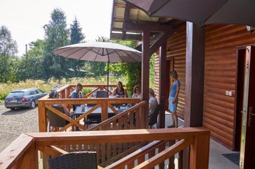 a group of people sitting at a table under an umbrella at Leśne Berdo Przysłup in Cisna
