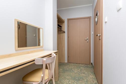 a room with a desk with a chair and a mirror at Hotel Vela in Tczew