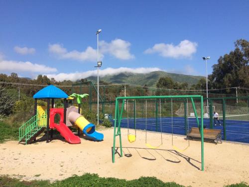 un parque infantil con pista de tenis en Condominio Laguna Papudo, en Papudo