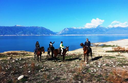 a group of people riding horses by the water at RAHAT Guest House & Hostel in Toktogul in Toktogul