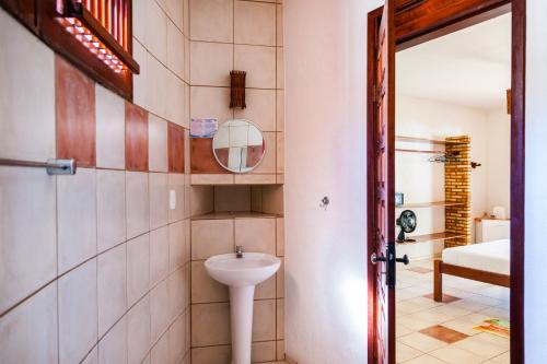 a bathroom with a sink and a mirror at Casa Cumbuco e Hospedaria in Cumbuco