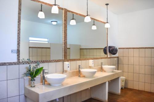 a bathroom with three sinks and a large mirror at Hotel y Resort Quinta del Sol in San José Pinula