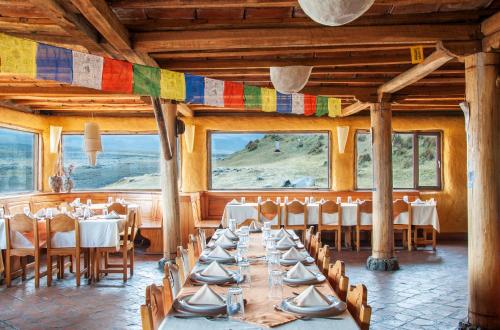 a dining room with tables and chairs and flags at Hotel Tambopaxi in Machachi
