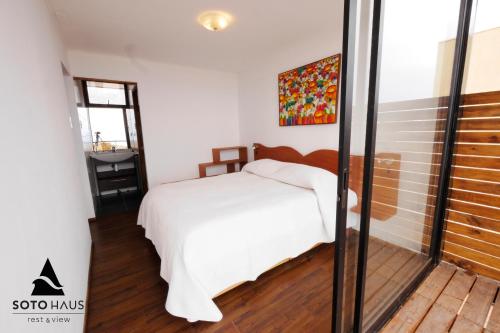 a bedroom with a white bed and a window at SOTO HAUS Totoralillo Mar in Totoralillo