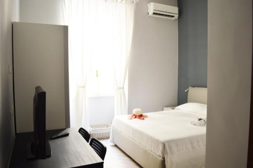 a bedroom with a bed and a television and a window at Colosshouse guest house in Rome