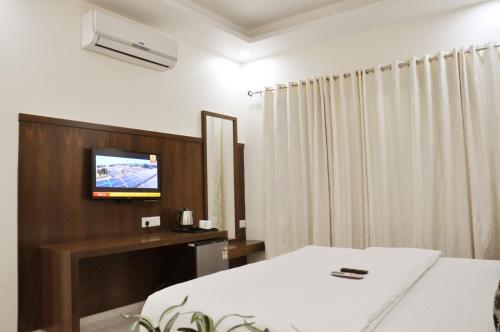 Una televisión o centro de entretenimiento en Hotel Sai Shubham