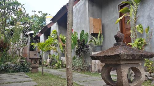 a building with a statue next to a tree at Made Oka Homestay and Warung in Munduk