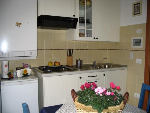 a kitchen with a table with a basket of flowers on it at B&B Casa Francesca in Alano di Piave