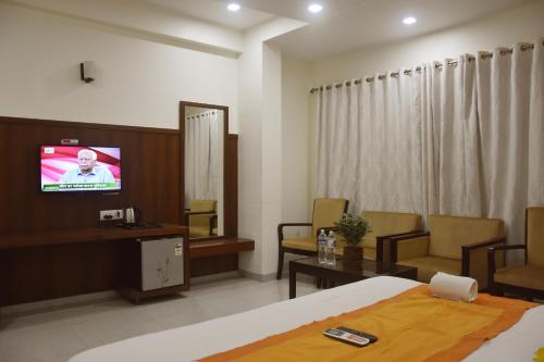 Una televisión o centro de entretenimiento en Hotel Sai Shubham