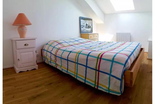 フォール・マオン・プラージュにあるLazyloc - superbe duplex face merのベッドルーム1室(ベッド1台、ランプ付きテーブル付)