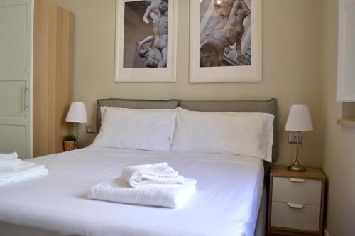 a white bed with two towels on top of it at Domus Duomo in Florence