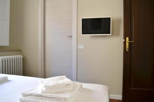 a room with a bed with a television on the wall at Domus Duomo in Florence