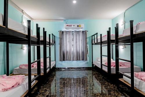 a room with four bunk beds and a window at The Guest Hotel Krabi in Krabi town