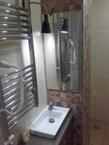 y baño con lavabo y espejo. en Errica Apartment en Preveza