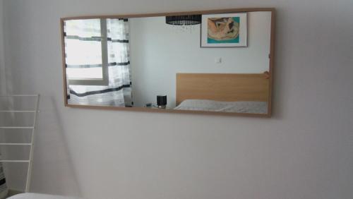 a mirror hanging on a wall in a bedroom at Luxury Spa Apartment Luna in Njivice