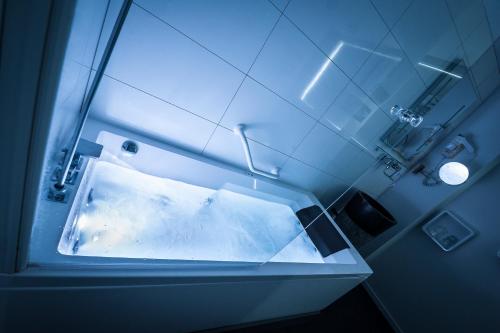 a bathroom with a tub with a water fountain at The Originals Boutique, Hôtel Bulles by Forgeron, Lille Sud (Qualys-Hotel) in Seclin