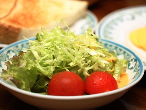 a bowl of lettuce and tomatoes on a table at Pension Raisin in Kusatsu