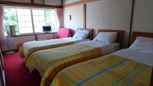 Postel nebo postele na pokoji v ubytování Inn Yamanami