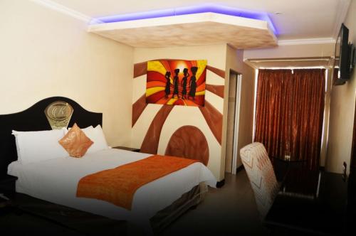 Schlafzimmer mit einem Bett mit Wandgemälde in der Unterkunft Kismet Hotel in Pietermaritzburg