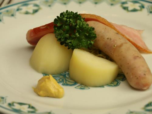 a plate of food with a hot dog and potatoes at Pension Raisin in Kusatsu