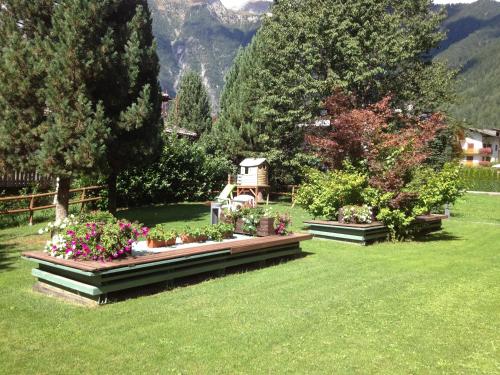 a garden with some flowers in the grass at Hotel Cristina in Pinzolo