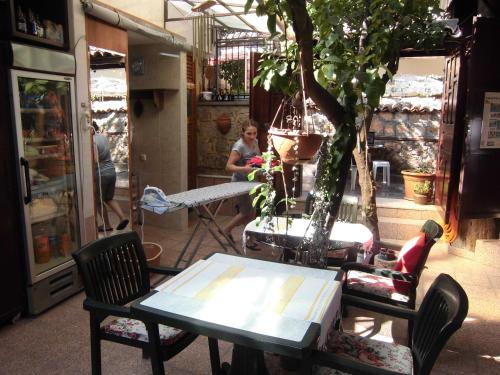 a woman sitting at a table in front of a store at Sultan Pension in Antalya