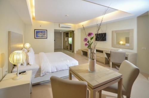 Schlafzimmer mit einem Bett und einem Tisch mit Stühlen in der Unterkunft The Muse Hotel in Boracay