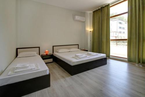 シュコルピロフツにあるApartments Karinaの大きな窓付きの客室で、ベッド2台が備わります。