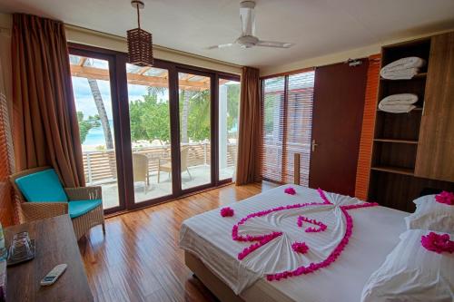 a bedroom with a bed with pink flowers on it at Kinan Retreat in Fulidhoo