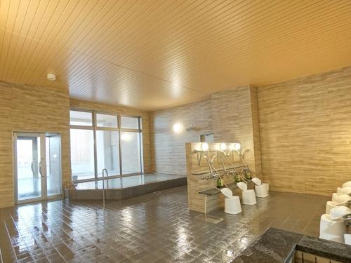 a large room with a bath tub in a building at Hotel La'gent Plaza Hakodate Hokuto in Hokuto
